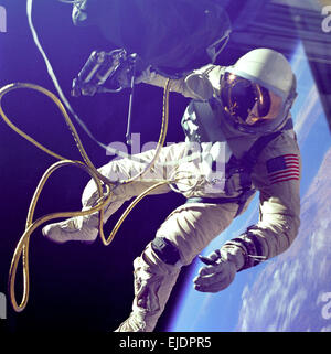 Ed White, First American Spacewalk. Edward H. White II became the first American to step outside his spacecraft and let go, effectively setting himself adrift in the zero gravity of space. For 23 minutes White floated and maneuvered himself around the Gemini spacecraft while logging 6,500 miles during his orbital stroll. White was attached to the spacecraft by a 25 foot umbilical line and a 23 foot tether line, both wrapped in gold tape to form one cord. In his right hand, White carries a Hand Held Self Maneuvering Unit, which is used to move about the weightless environment Stock Photo