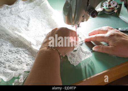 Hands of a dressmaker supporting a cloth while sewing on a sewing machine, Spain Stock Photo