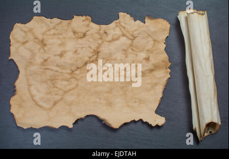old piece of paper and paper roll on black background Stock Photo