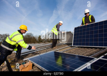 Leo Smith from Southern Solar and Andy Tyrrell and Jake Beautyman install solar panels on a barn roof on Grange farm, near Balco Stock Photo