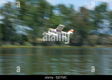 Radio controlled Hydroplane flying  over the Guadiana river surface, Badajoz, Spain. The image shows motion blur Stock Photo