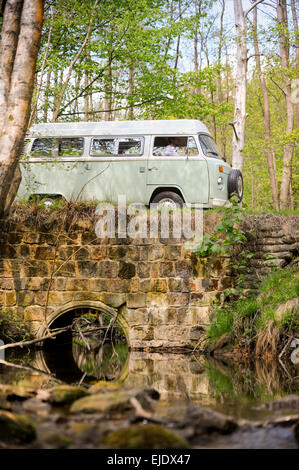 Volkswagen Camper crossing a bridge over a stream on the Ashdown Forest in East Sussex UK. Stock Photo