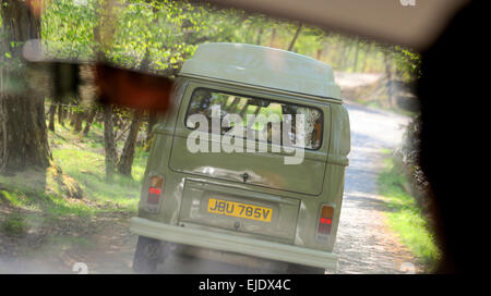 A Volkswagen Camper bus on a country lane in East Sussex viewed from the inside of a second camper bus. Stock Photo