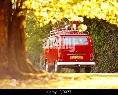 A red Volkswagen Camper bus on country road of East Sussex UK. Stock Photo