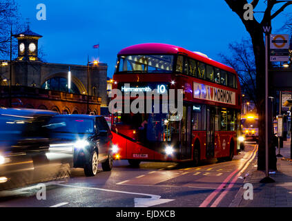 Modern double decker red London bus at night next to a bus stop on Euston Road in central London England UK Stock Photo