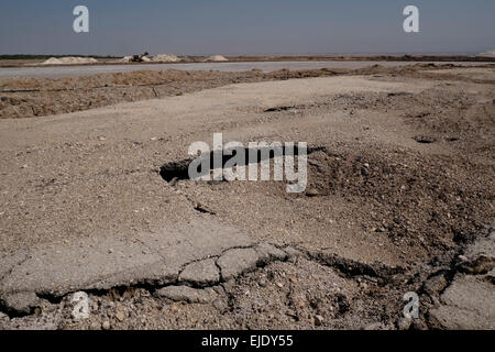 View of damage to asphalt road caused by Sinkholesat at the northern shores of the Dead Sea, Israel Stock Photo