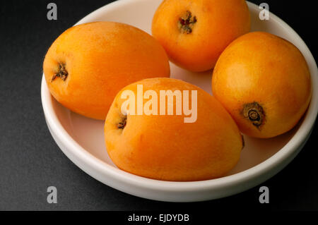 Loquats in bowl closeup Stock Photo