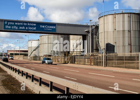 The Courier advertisement banner on a bridge walkway leading to the large oil storage tanks in Dundee, UK Stock Photo