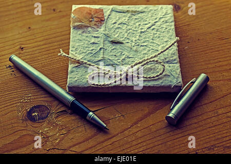 Old diary memories with a pen on a wooden table. Vintage processing. Stock Photo