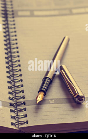 Open notebook with a fountain pen. Vintage processing. Stock Photo