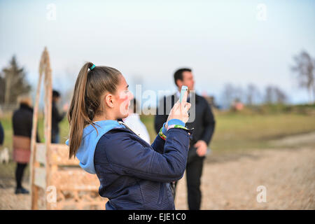 Teenage girl using mobile phone to take a photograph. Stock Photo