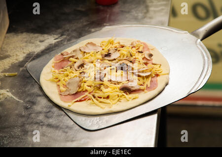 Fresh made pizza on utensil shovel ready to be placed in owen. Photo from real I mean REAL pizza place! Stock Photo