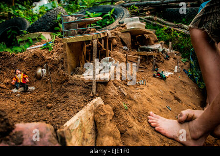 A boy stands by his miniature world made for figurines in the summer, Pittsburgh, Pennsylvania Stock Photo