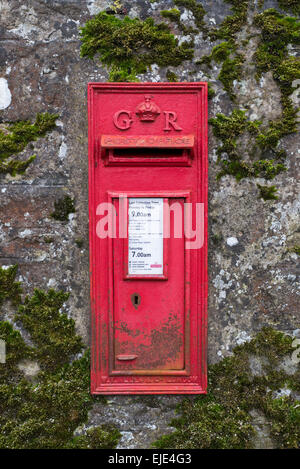 Red postbox from the reign of King George V set in a moss covered wall in Balerno on the outskirts of Edinburgh. Stock Photo