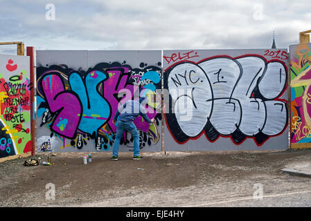 Graffiti artist working on the legal boards in New Street Edinburgh. Stock Photo