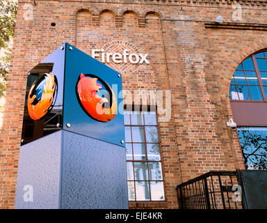 The Firefox headquarters in San Francisco features a modern logo monument in front of a historic brick building with large arched windows. Stock Photo