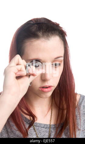 Teenage Girl Curling Eyelashes with Eyelash Curler Stock Photo