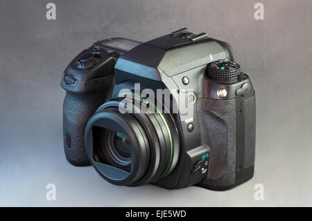 Digital single lens reflex black camera and wide angle lens against gray background Stock Photo