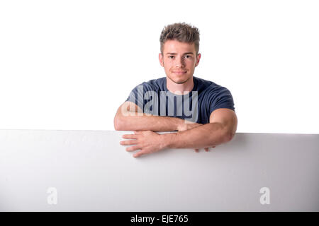 Handsome young man behind a blank horizontal white banner looking at camera, isolated on white Stock Photo