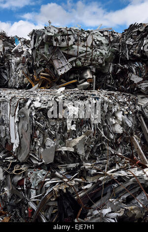 Recycling dump with bales of crushed recycled scrap metal and blue sky clouds Toronto Stock Photo