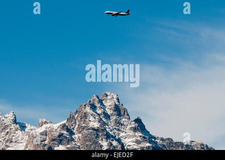 Commercial United 737 jet approaching Jackson airport flying over Grand Teton Peak Stock Photo
