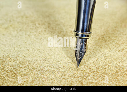 Closeup of an elegant fountain pen on vintage grunge background Stock Photo