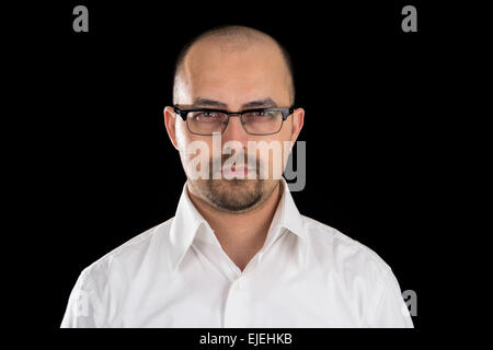 portrait of handsome young man wearing glasses against black background Stock Photo