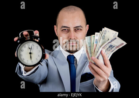 man holding money and alarm wearing a business suit, race against the clock, deadline Stock Photo