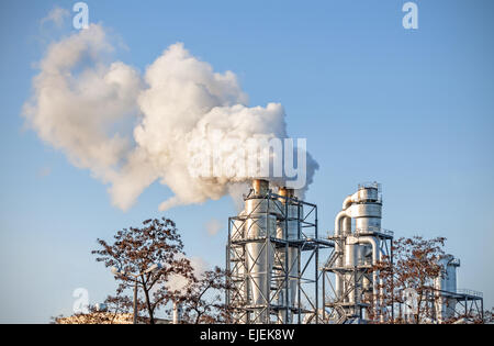 Smoking chimneys over blue sky, air pollution concept. Stock Photo