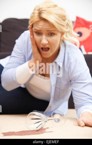 Woman Accidentally Spilling Red Wine On Carpet At Home Stock Photo