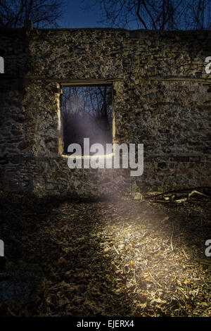 Light Shining Through Window In Old Stone Wall At Night Stock Photo