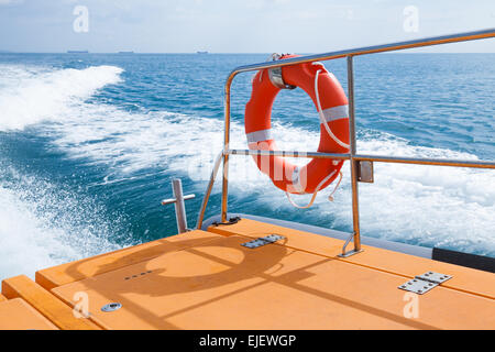 Red lifebuoy hanging on railings of fast safety rescue boat Stock Photo