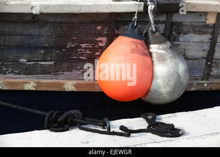 Red and white small rubber buoys for protecting moored yachts in marina, vintage toned photo with old style filter effect Stock Photo