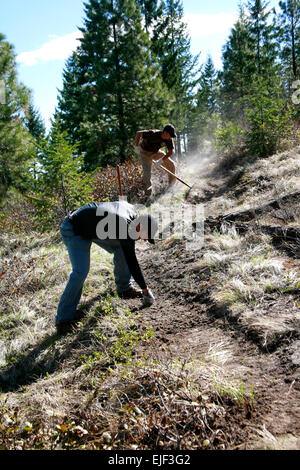 Two volunteers help build a new mountain bike single track trail at Echo Ridge Stock Photo