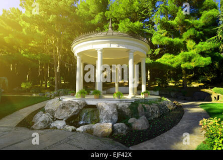 White bower among the coniferous trees in park Stock Photo