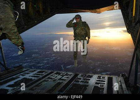 A U.S. Soldier assigned to 1st Battalion, 10th Special Forces Group Airborne salutes his fellow Soldiers while jumping out of a C-130 Hercules aircraft over a drop zone in Germany, Feb. 24, 2015.  Visual Information Specialist Jason Johnston Stock Photo