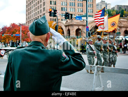 Retired Army 1st Sgt. William Staude, of Elliott, Pa., salutes soldiers from the 316th Expeditionary Sustainment Command, stationed in Coraopolis, Pa., as they march past him during the Veterans Day parade in downtown Pittsburgh, Nov. 11. Stock Photo