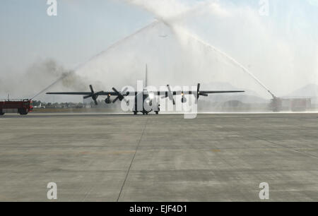 KABUL, Afghanistan - Two fire trucks spray water over a C-130 Hercules transport aircraft as it taxies on the runway at the Kabul International Airport, Oct. 9, 2013. Two cargo planes were dedicated during a formal ceremony attended by Afghan National Security Force and International Security Assistance Force senior leaders as well as Government of the Islamic Republic of Afghanistan dignitaries. The Afghan air force took delivery of its first two C-130 cargo planes that will boost ANSF military capabilities as they assume the lead for the security of their country.  Staff Sgt. Richard Andrade Stock Photo