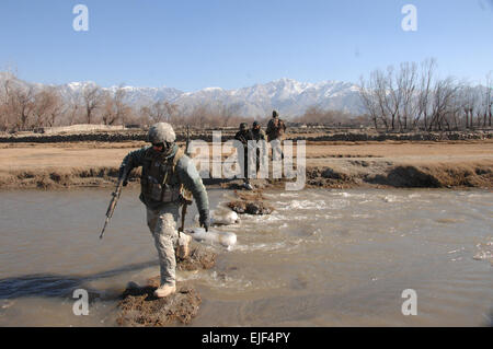 Afghan National Army and coalition forces soldiers rmove west across a wadi back to Main Supply Route Vermont in the Tagab District, Kapisa Province, Afghanistan Jan. 19, 2008, after a security patrol.  Sgt. Johnny R. Aragon Released Stock Photo