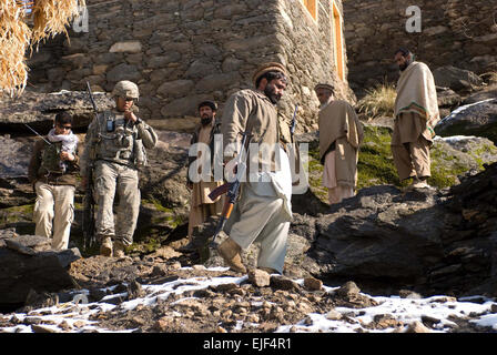 1st Lt. Kareem F. Hernandez, a New York and New Jersey resident and also 2nd Platoon Leader in Able Company, 2nd Battalion, 503rd Infantry Regiment Airborne, talks on the radio while village elders and a Afghan National Policeman walk down the mountain during a patrol to Omar in Kunar Province Afghanistan Jan. 11. Stock Photo