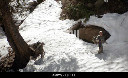 Soldiers in 3rd Platoon, Combat Company, 1-32 Infantry climb into the snowline of a mountain near the village of Aybat in Eastern Afghanistan during a two week long mission including patrols, air assaults and talks with the local elders to establish a link between the local populace and the Afghan government.  Army Spc. Jon H. Arguello Stock Photo