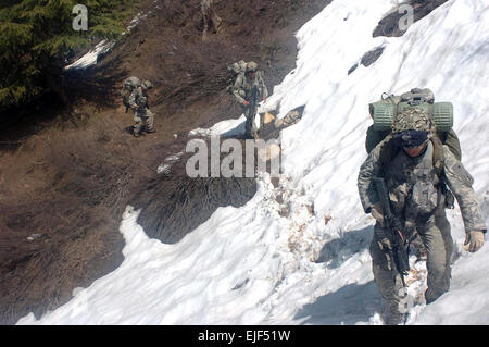 Soldiers in 3rd Platoon, Combat Company, 1-32 Infantry climb into the snowline of a mountain near the village of Aybat in Eastern Afghanistan during a two week mission including patrols, air assaults and talks with the local elders designed to establish a link between the local populace and the Afghan government.  Spc. Jon H. Arguello Stock Photo