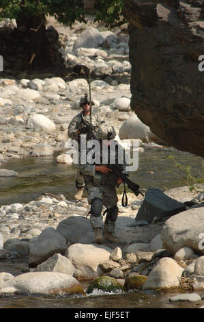 U.S. Army 1st Lt. John Norden and Sgt. Brendan Johnson, from Headquarters, Headquarters Battery, 4th Battalion, 319th Airborne Field Artillery Regiment, 173rd Airborne Brigade Combat Team, walk next to the Titin River while on a foot patrol in the Titin Valley of the Nuristan province of Afghanistan June 21, 2007. U.S. Army photo Staff Sgt. Isaac A. Graham Stock Photo