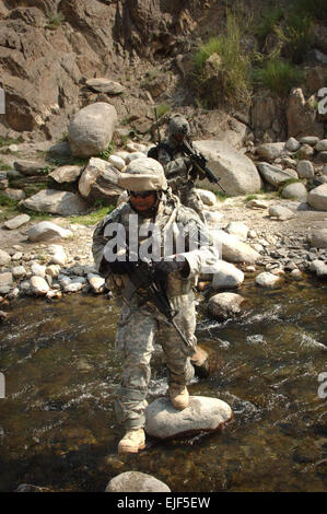 U.S. Army 1st Lt. Jay Richardson, from Headquarters, Headquarters Battery, 4th Battalion, 319th Airborne Field Artillery Regiment, 173rd Airborne Brigade Combat Team, walks on stones to cross the Titin River while on a foot patrol in the Titin Valley of the Nuristan province of Afghanistan June 21, 2007. U.S. Army photo Staff Sgt. Isaac A. Graham Stock Photo