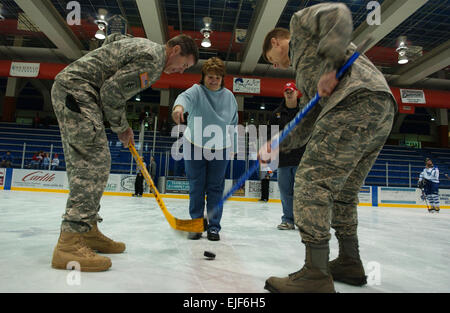 Terry Strie, mayor of Fairbanks, Alaska, drops the honorary puck drop while U.S. Air Force Brig. Gen. Mark Graper, right, representing Eielson Icemen face off with U.S. Army Lt. Col. Ronald Johnson, left, representing Fort Wainwright Grizzlies Feb. 23, 2008, at the Big Dipper Ice Arena on Eielson Air Force Base, Alaska, during the 12th annual Commanders' Cup. U.S. Air Force photo/Airman 1st Class Jonathan Snyder Stock Photo