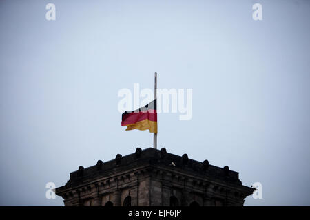 Berlin, Germany. 25th Mar, 2015. A German national flag flies at half mast on the Reichstag building (the lower house of parliament) to commemorate the victims of the crashed plane of Germanwings in Berlin, Germany, on March 25, 2015. An Airbus A320 of the German low-cost airline Germanwings with 150 people on board crashed on Tuesday in southern France. © Zhang Fan/Xinhua/Alamy Live News Stock Photo