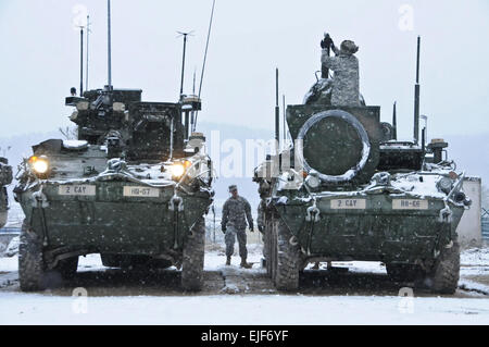 Dragoon troopers assigned to Regimental Headquarters and Headquarters Troop, 2nd Cavalry Regiment along with Soldiers assigned to the Dutch 42nd Battle Group perform Preventive Maintenance and Services to their equipment while constructing a Regimental Tactical Operations Center during Allied Spirit I at Hohenfels Training Area located in Hohenfels, Germany, Jan. 20, 2015. The purpose of the exercise is to conduct multinational training as well as improving allied interoperability between U.S. and NATO forces. Stock Photo