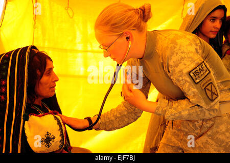 Spc. Margie Huelskamp, a medic attached to 3rd Battalion, 6th Field Artillery of the 10th Mountain Divisionís 1st Brigade Combat Team, listens to the heartbeat of a local woman at the Ghormach Clinic during a medical mission on Oct. 2, 2010.  Over two days, more than 400 people from throughout the Ghormach District were seen by two medical providers and seven medics from 1st Brigade Combat Team.   Spc. Blair Neelands, U.S. Army. Stock Photo