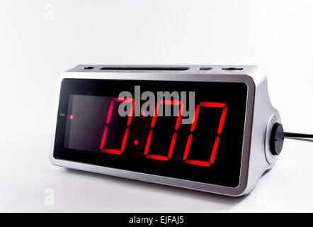 A retro looking silver digital alarm clock at six thirty 6 30am in red ...