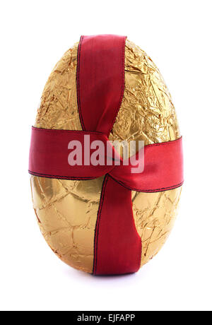 Gold easter egg covered in foil with a red silk ribbon Stock Photo
